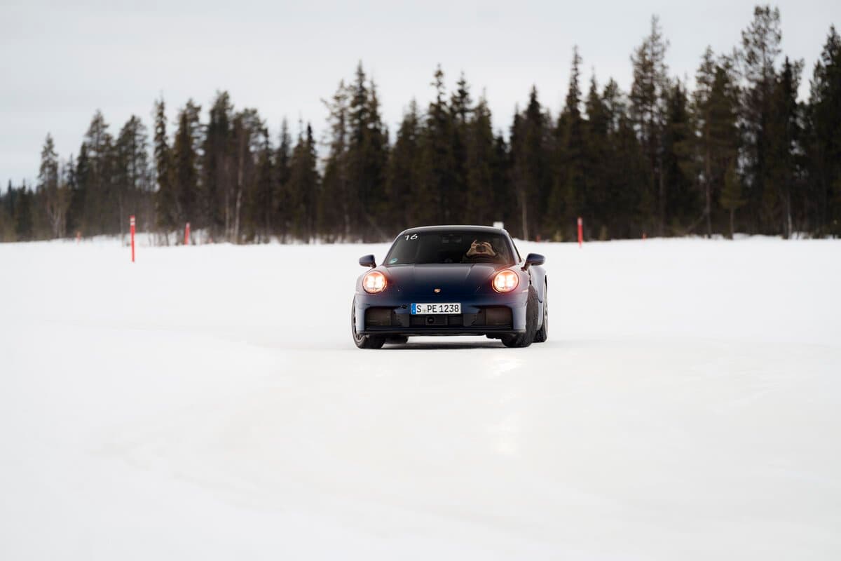 Porsche 911 on snow track with headlights